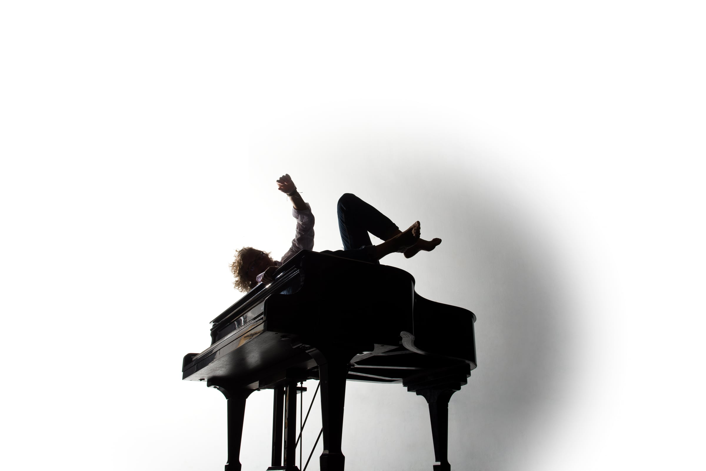 Fotografía del artista encima de un piano